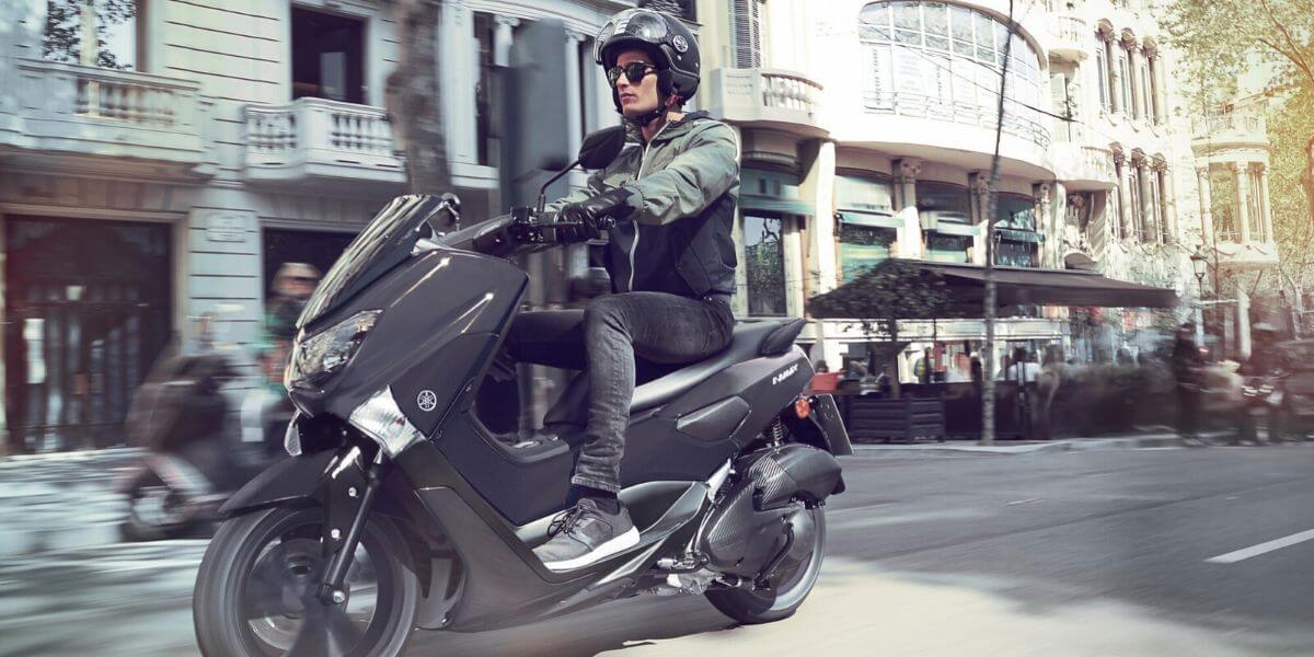 Un homme conduit un scooter en ville - comment choisir son assurance scooter ?